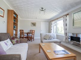 A living room with a dining table and sofas at Jenny Wren Tywardreath near Fowey