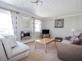 A living room with a television and sofa at Jenny Wren in Tywardreath near Fowey