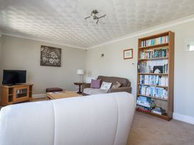 A living room with a television and bookshelves at Jenny Wren in Tywardreath near Fowey