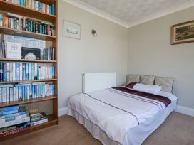 A bedroom with a bed and bookshelf at Jenny Wren in Tywardreath near Fowey