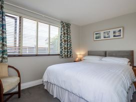 A bedroom with a double bed and a chair at Jenny Wren in Tywardreath near Fowey