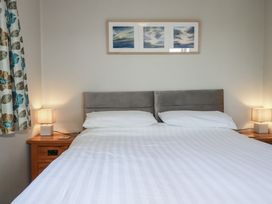 A bedroom with a bed and bedside tables at Jenny Wren in Tywardreath near Fowey