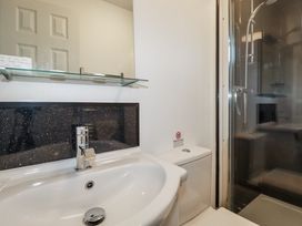 A bathroom with a sink, toilet, and shower at Jenny Wren in Tywardreath near Fowey