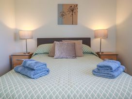 A bedroom with a bed, pillows, and lamps at The Station Flat in St Newlyn East near Newquay