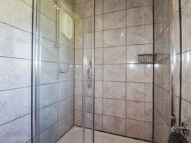 A shower enclosure with grey tiles at The Station Flat in St Newlyn East near Newquay