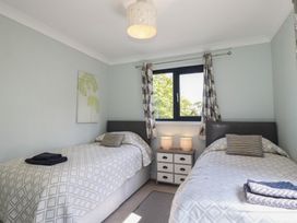 A bedroom with two single beds and a bedside table at The Station Flat St Newlyn East near Newquay