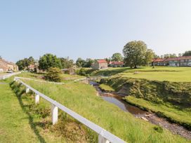 A view of houses and a stream in a rural area at Brookleigh Hutton-le-Hole