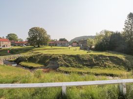 An outdoor area with houses and people walking dogs at Brookleigh in Hutton-le-Hole