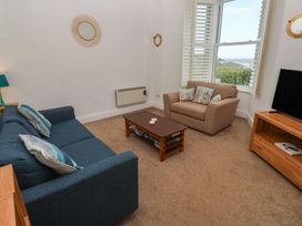 A living room with a sofa and armchair at Apartment 1 Llewellan in St Ives