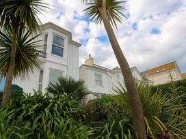 A house with palm trees and plants in the garden at Apartment 1 Llewellan in St Ives