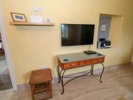 A living room with a television and console table at Ballaghboy Cottage in Boyle, County Sligo