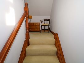 A staircase with a chair and dresser at Ballaghboy Cottage in Boyle, County Sligo