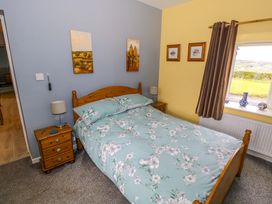 A bedroom with a bed and window at Ballaghboy Cottage in Boyle, County Sligo