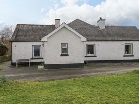 A house with windows and a bench outside at Ballaghboy Cottage in Boyle, County Sligo