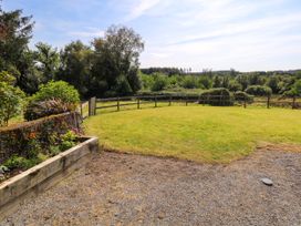 A garden with a flower bed and a wooden fence at Ballaghboy Cottage in Boyle, County Sligo