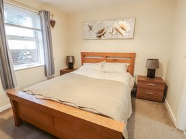 A bedroom with a bed and bedside tables at Beach View in Benllech near Red Wharf Bay