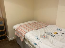 A bed with a patterned blanket in a bedroom at Beach View Benllech near Red Wharf Bay