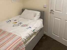 A bedroom with a bed and door at Beach View, Benllech near Red Wharf Bay