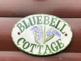 A decorative sign that reads Bluebell Cottage with flower design at Bluebell Lodge Saltburn-by-the-Sea