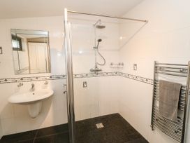 A bathroom with a walk-in shower a sink with a mirror and a towel rack at Violet Lodge in Saltburn-by-the-Sea
