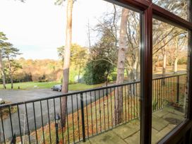 View of trees and a parked car from a balcony with metal railing at Violet Lodge in Saltburn-by-the-Sea