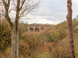 A landscape with trees and a brick arched bridge in the distance at Violet Lodge in Saltburn-by-the-Sea