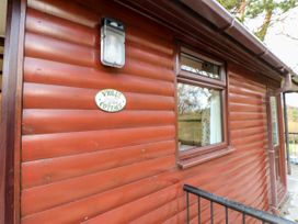 Exterior view of a wooden cottage wall with a window a light fixture and a sign saying violet cottage at Violet Lodge in Saltburn-by-the-Sea