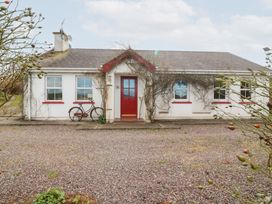 A cottage with a red door and gravel driveway at Herons Cove Cottage Ballydehop