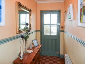 A hallway with a table and mirror at Herons Cove Cottage in Ballydehop