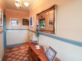 A hallway with a mirror and wall art at Herons Cove Cottage Ballydehop