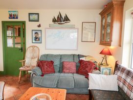 A living room with a sofa and rocking chair at Herons Cove Cottage Ballydehop
