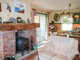 A kitchen with a stove and table at Herons Cove Cottage Ballydehop