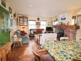 A living room with a sofa and dining table at Herons Cove Cottage in Ballydehop