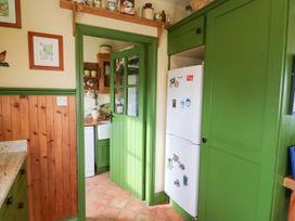 A kitchen with a fridge and cabinets at Herons Cove Cottage in Ballydehop