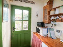 A kitchen with a green door and countertop appliances at Herons Cove Cottage, Ballydehop