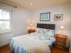 A bedroom with a bed and bedside tables at Herons Cove Cottage Ballydehop