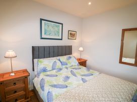 A bedroom with a bed and nightstands at Herons Cove Cottage Ballydehop