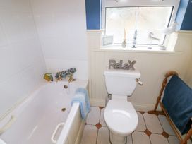 A bathroom with a bath tub and toilet at Herons Cove Cottage in Ballydehop