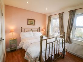 A bedroom with a bed and nightstand at Herons Cove Cottage Ballydehop