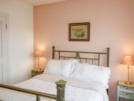 A bedroom with a bed and bedside tables at Herons Cove Cottage in Ballydehop