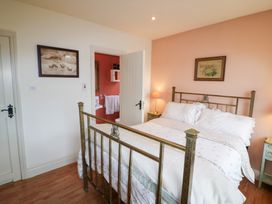 A bedroom with a bed and a lamp at Herons Cove Cottage Ballydehop