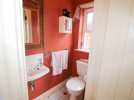 A bathroom with a sink, toilet, and towel rack at Herons Cove Cottage in Ballydehop
