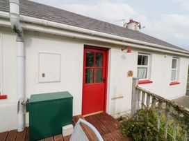 An outdoor area with a red door and green storage box at Herons Cove Cottage Ballydehop