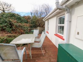 An outdoor seating area with a table and chairs at Herons Cove Cottage Ballydehop