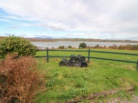 A view of grass and a fence with buckets at Herons Cove Cottage in Ballydehop