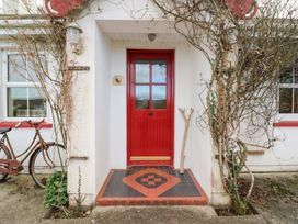 A front entrance with a red door and bicycle at Herons Cove Cottage Ballydehop