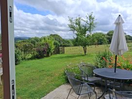 A garden with a table and chairs at Woodstone Barn Whitchurch near Tavistock