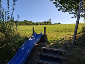 A slide with steps leading to a grassy area at Woodstone Barn Whitchurch near Tavistock