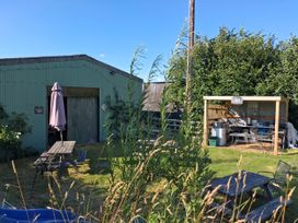 A garden with a table and shed at Woodstone Barn in Whitchurch near Tavistock