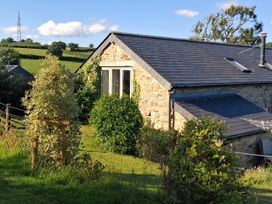 A building with a window and roof in a green field at Woodstone Barn in Whitchurch near Tavistock